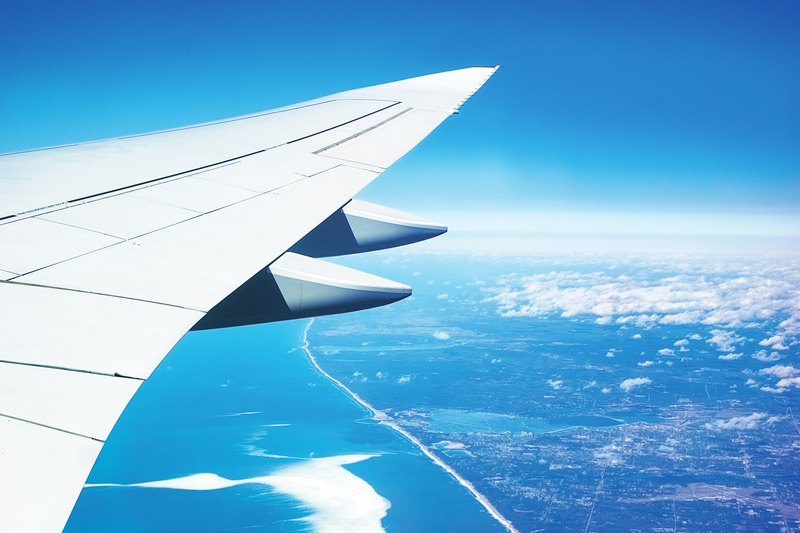 View from an aircraft window over a coastline in flight