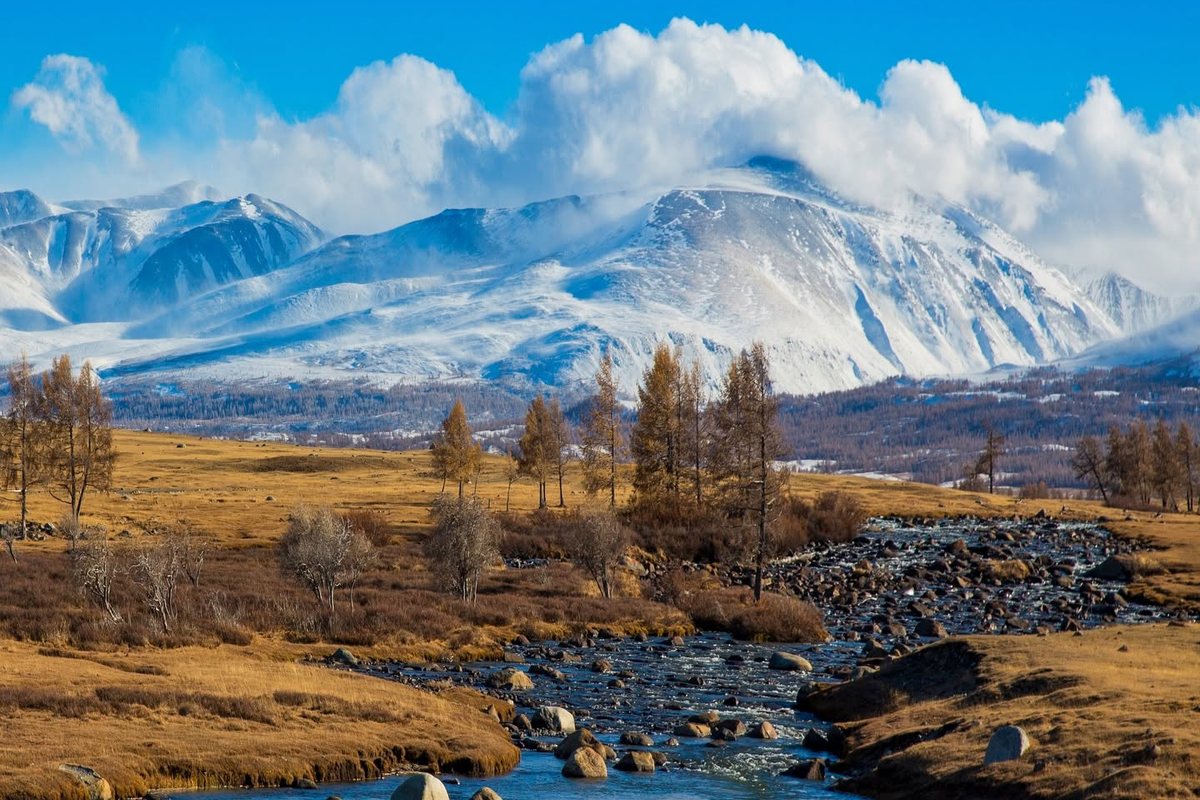 Snow-capped Altai mountains above a river and autumn steppe, western Mongolia