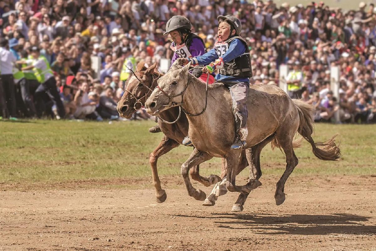 Young jockeys racing at the Naadam Festival horse race, Mongolia