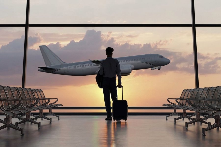 Traveller watching an aircraft take off from an airport departure lounge