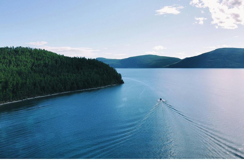 Boat crossing the clear waters of Lake Khuvsgul, Mongolia